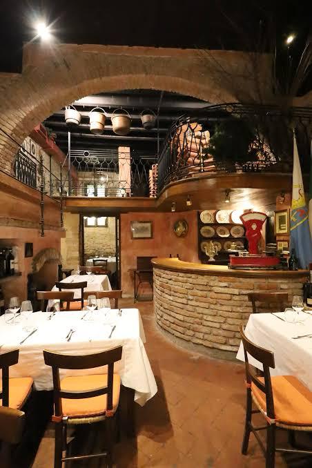 Sala rustica della Trattoria Bresciana con tavoli apparecchiati